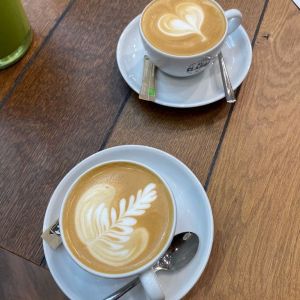 zwei Cappucinotassen mit schönem Milchsschaum auf Holztisch