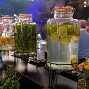 Große Glasbehälter mit eingelegten Zitronen und Deko an einer Bar